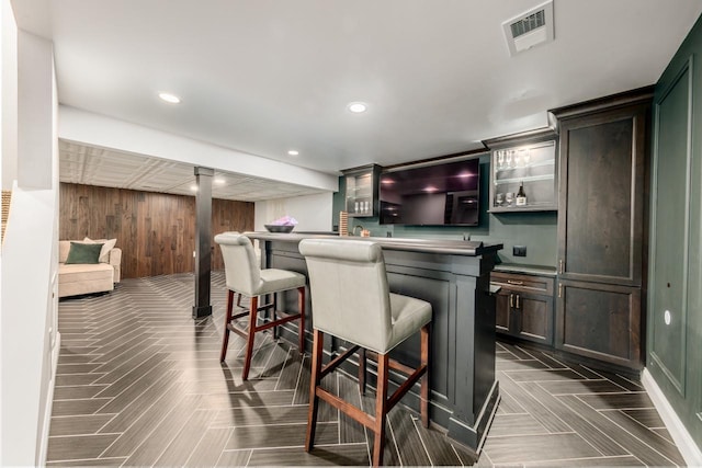 bar with wood walls, a dry bar, visible vents, and recessed lighting