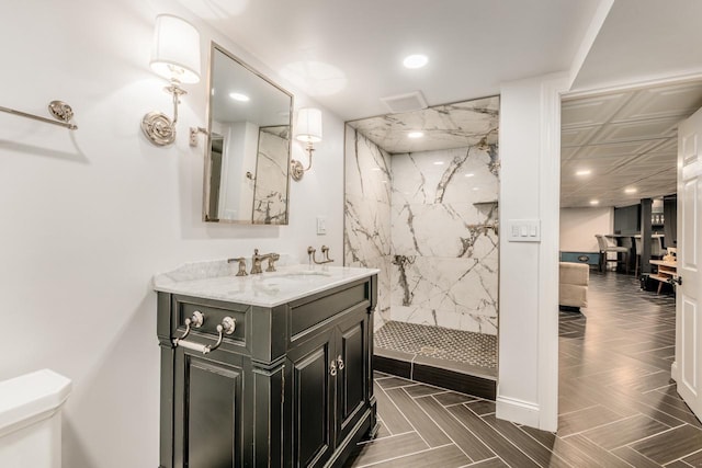 full bathroom with toilet, vanity, a marble finish shower, and recessed lighting
