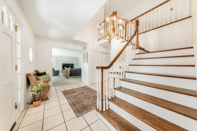 entrance foyer featuring stairway, tile patterned flooring, and a notable chandelier