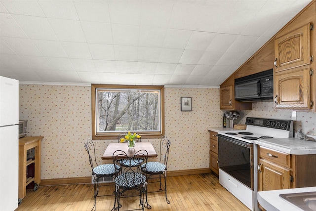 526 N Vine St, Appleton, WI 54911 - kitchen featuring white electric range oven, black microwave, light wood-style floors, and light countertops