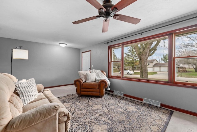 carpeted living area featuring ceiling fan, baseboards, and visible vents