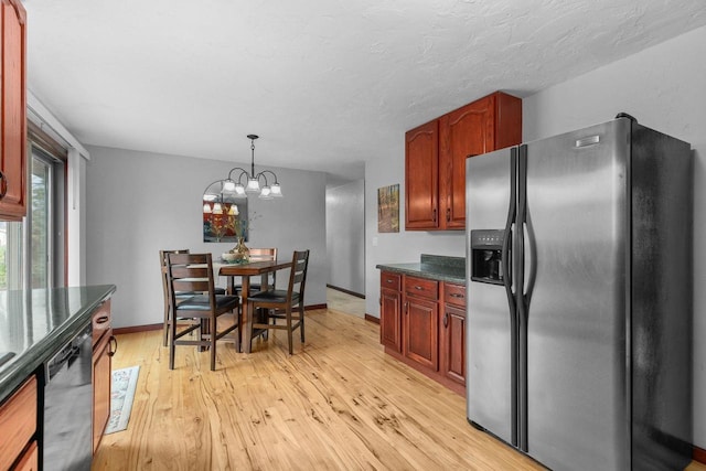 kitchen with dark countertops, stainless steel fridge, dishwasher, light wood-style flooring, and baseboards