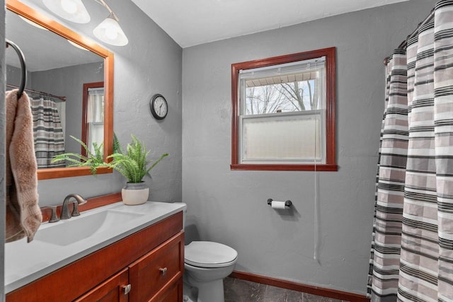 full bathroom featuring toilet, vanity, curtained shower, and baseboards