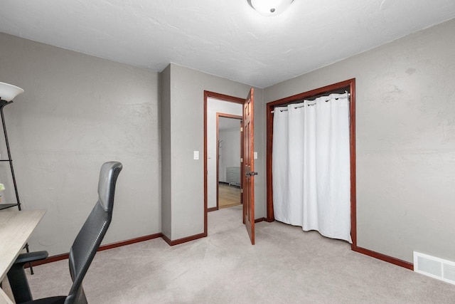 unfurnished office featuring baseboards, visible vents, and light colored carpet