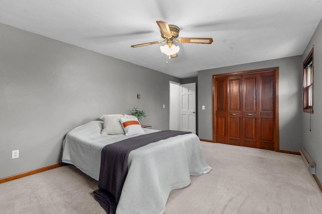 bedroom with baseboard heating, baseboards, carpet floors, and a closet