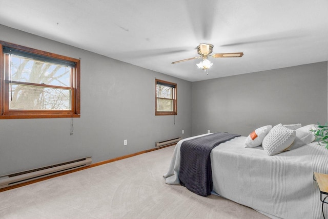 carpeted bedroom with baseboard heating, baseboards, and a ceiling fan