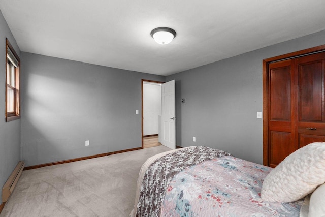 bedroom featuring a baseboard heating unit, baseboards, and light colored carpet