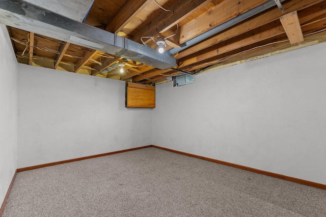 unfinished basement featuring carpet flooring and baseboards