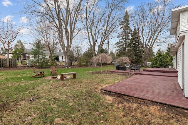 view of yard with a fire pit, a wooden deck, and fence