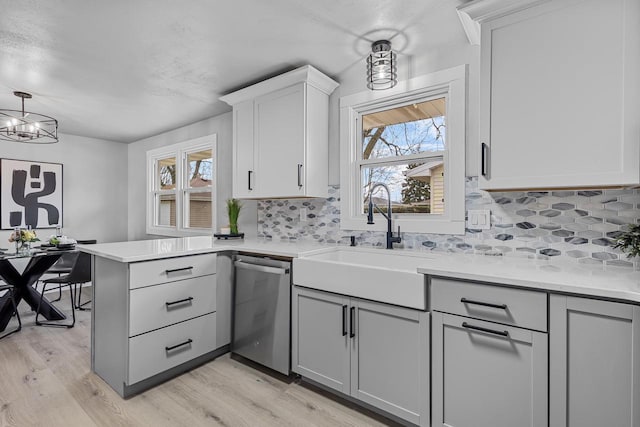 kitchen featuring light countertops, dishwasher, and a healthy amount of sunlight