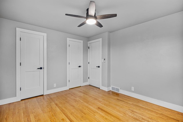 unfurnished bedroom with light wood finished floors, baseboards, ceiling fan, and visible vents