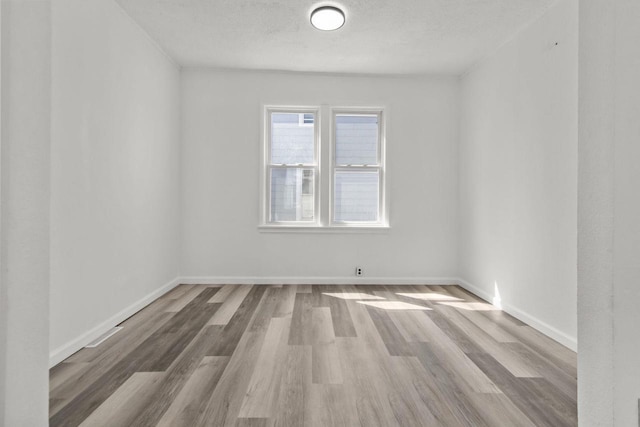 76 E Johnson St, Fond Du Lac, WI 54935 - empty room featuring baseboards, wood finished floors, and a textured ceiling