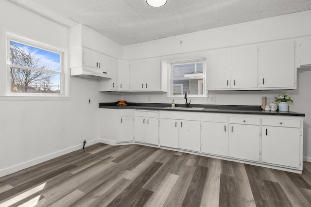 76 E Johnson St, Fond Du Lac, WI 54935 - kitchen featuring dark countertops, a sink, white cabinets, under cabinet range hood, and dark wood-type flooring