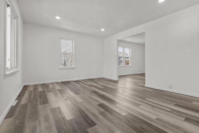 76 E Johnson St, Fond Du Lac, WI 54935 - unfurnished room featuring baseboards, wood finished floors, a textured ceiling, and recessed lighting