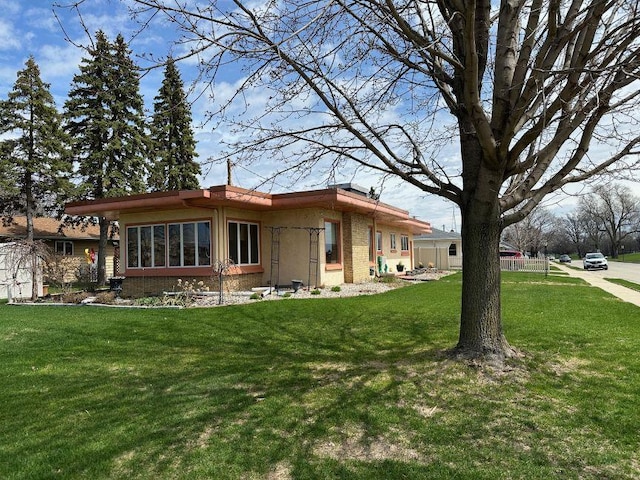 rear view of property with brick siding and a yard