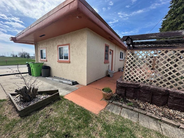 view of side of property with a patio and stucco siding