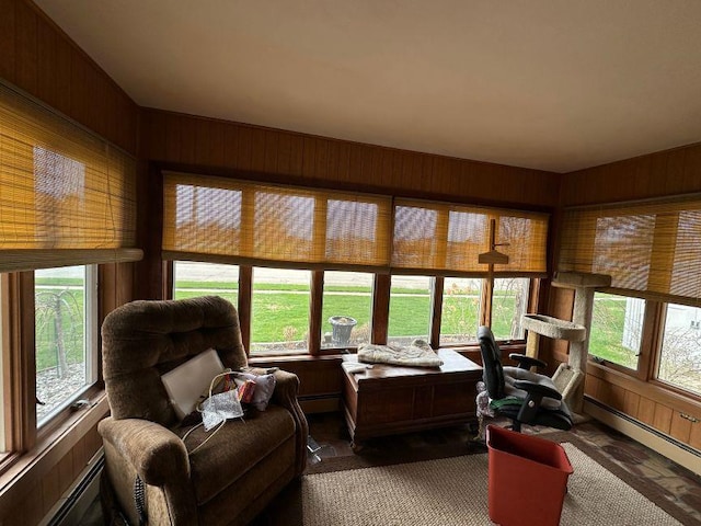 sunroom with baseboard heating, wood walls, and a wealth of natural light