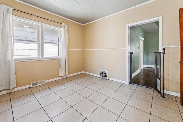 1931 Wood St, La Crosse, WI 54603 - spare room featuring baseboards, crown molding, light tile patterned flooring, and visible vents