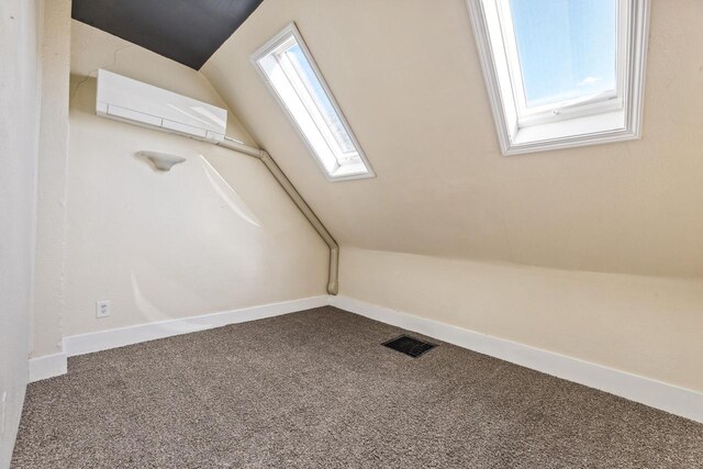1931 Wood St, La Crosse, WI 54603 - additional living space with lofted ceiling with skylight, carpet floors, baseboards, visible vents, and a wall unit AC