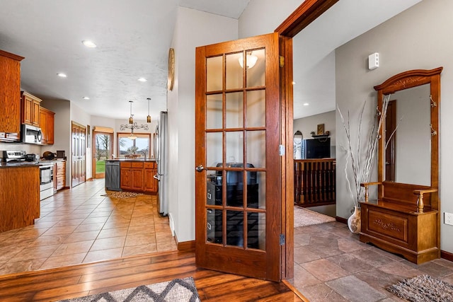 corridor featuring baseboards, recessed lighting, and a sink