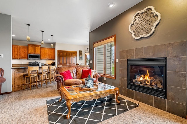 living room featuring carpet, recessed lighting, and a fireplace