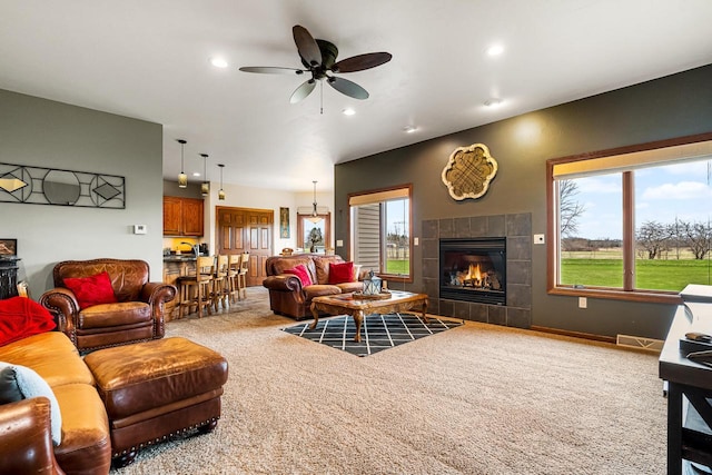 living room featuring a ceiling fan, a wealth of natural light, recessed lighting, and a fireplace