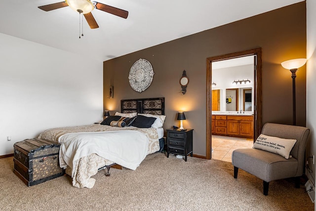 bedroom featuring ensuite bath, ceiling fan, light carpet, and baseboards