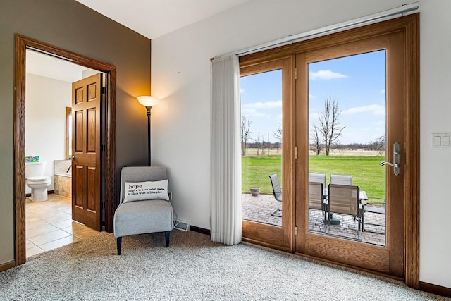 doorway featuring baseboards, visible vents, and carpet