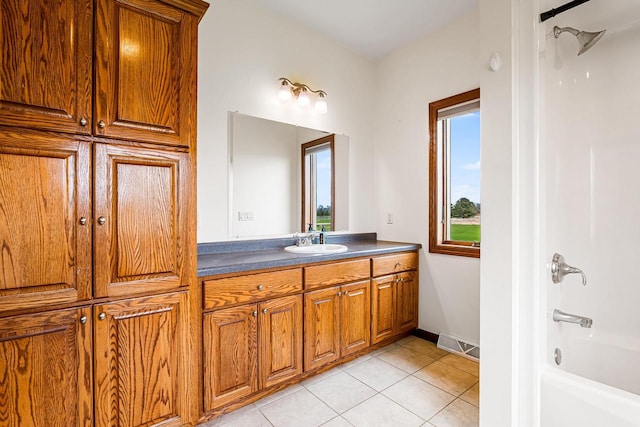 bathroom featuring tile patterned floors, visible vents, vanity, baseboards, and shower / bathing tub combination