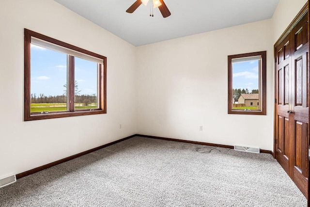 unfurnished bedroom with visible vents, carpet flooring, and multiple windows