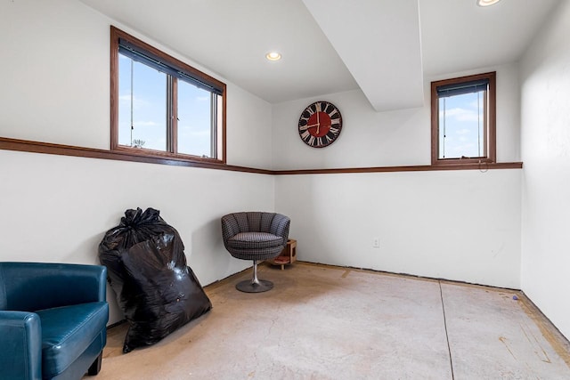 sitting room featuring concrete flooring and recessed lighting