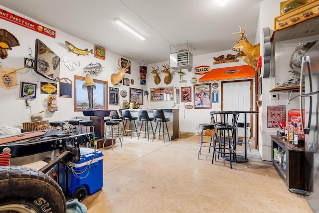 interior space with a dry bar and finished concrete floors