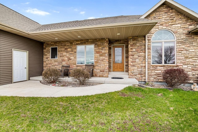 doorway to property featuring a lawn, roof with shingles, and stone siding