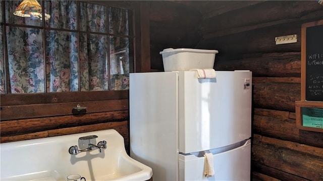 6051 Elsie Rd, Stone Lake, WI 54876 - detailed view of log walls and freestanding refrigerator