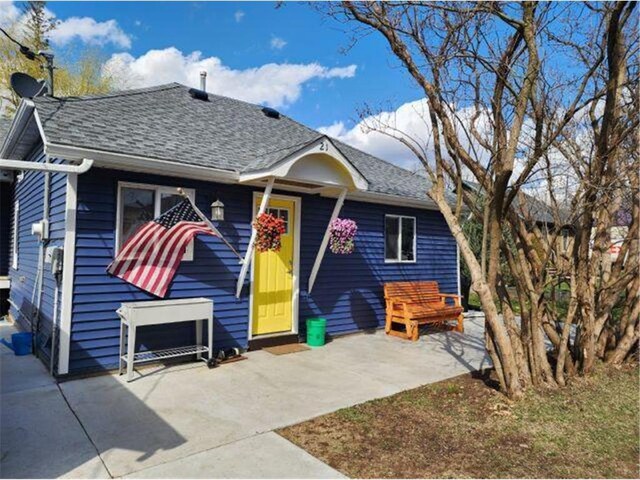21 N Main St, Luck, WI 54853 - view of front of house featuring a patio area and a shingled roof
