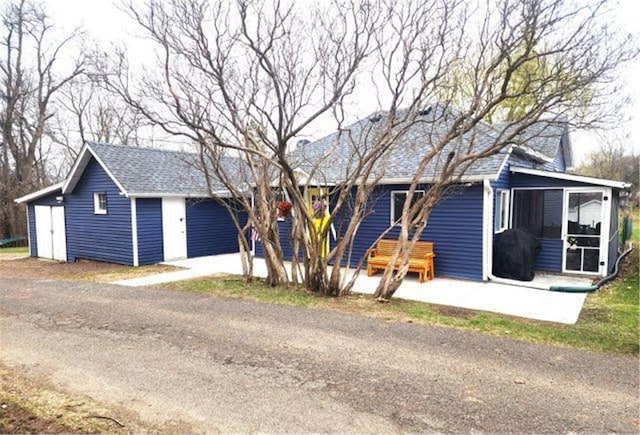 21 N Main St, Luck, WI 54853 - single story home featuring a sunroom, roof with shingles, and a garage