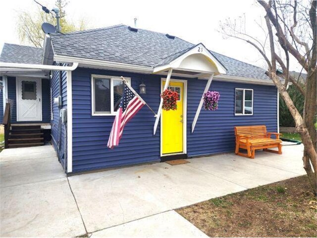 21 N Main St, Luck, WI 54853 - view of front facade with a shingled roof, entry steps, and a patio