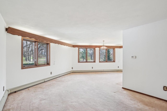 spare room with baseboards, a baseboard heating unit, a notable chandelier, and light carpet