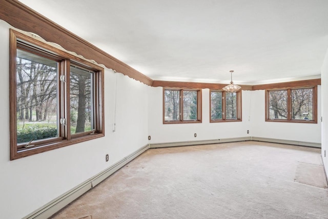 carpeted spare room with a baseboard heating unit, a notable chandelier, and a wealth of natural light