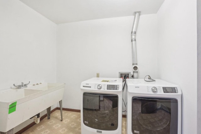 washroom featuring a sink, separate washer and dryer, laundry area, and light floors