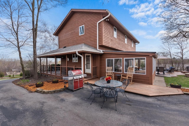 rear view of property featuring a patio area, outdoor dining area, and a deck