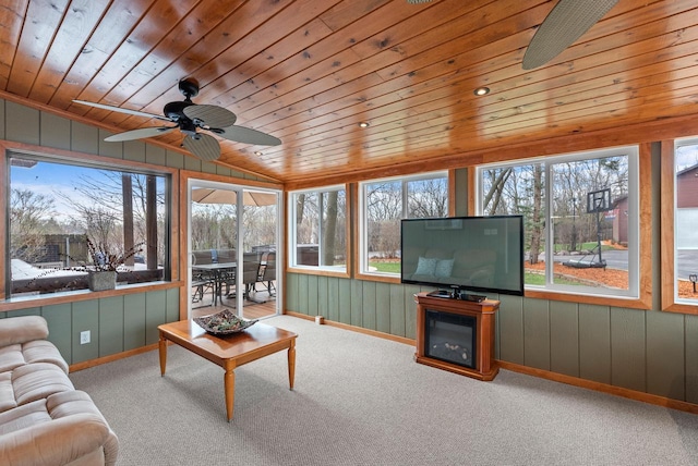 sunroom / solarium featuring wooden ceiling, wooden walls, carpet floors, and a healthy amount of sunlight