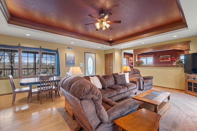living area with ceiling fan, a raised ceiling, baseboards, visible vents, and recessed lighting