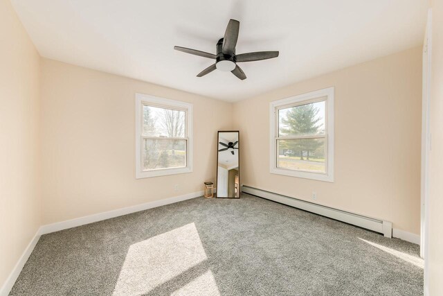 W2252 Spring Lake Rd, Markesan, WI 53946 - carpeted empty room featuring baseboards, a healthy amount of sunlight, a ceiling fan, and baseboard heating