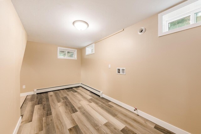 W2252 Spring Lake Rd, Markesan, WI 53946 - washroom featuring a baseboard radiator, light wood finished floors, baseboards, and laundry area