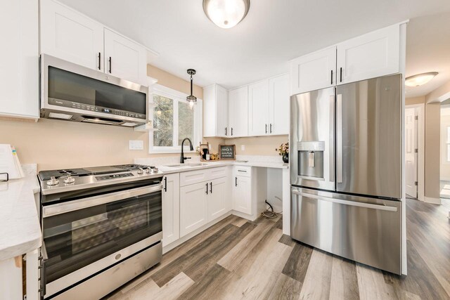 W2252 Spring Lake Rd, Markesan, WI 53946 - kitchen with a sink, light wood finished floors, light countertops, white cabinets, and appliances with stainless steel finishes