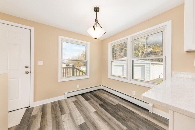 W2252 Spring Lake Rd, Markesan, WI 53946 - unfurnished dining area with a baseboard heating unit, wood finished floors, and a healthy amount of sunlight