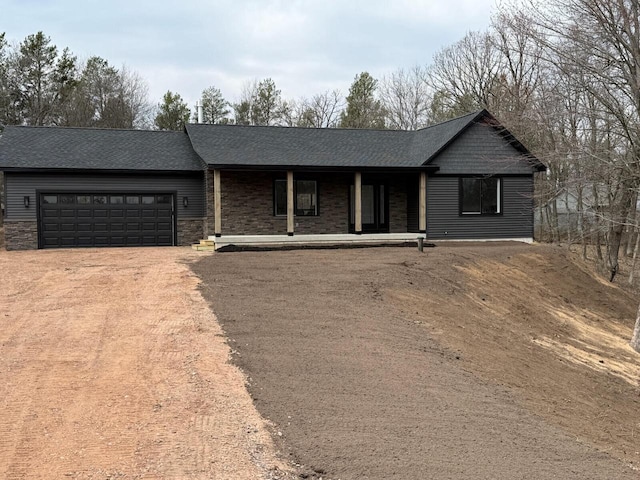 365 13th Dr, Nekoosa, WI 54457 - ranch-style home featuring driveway, stone siding, a garage, and a shingled roof