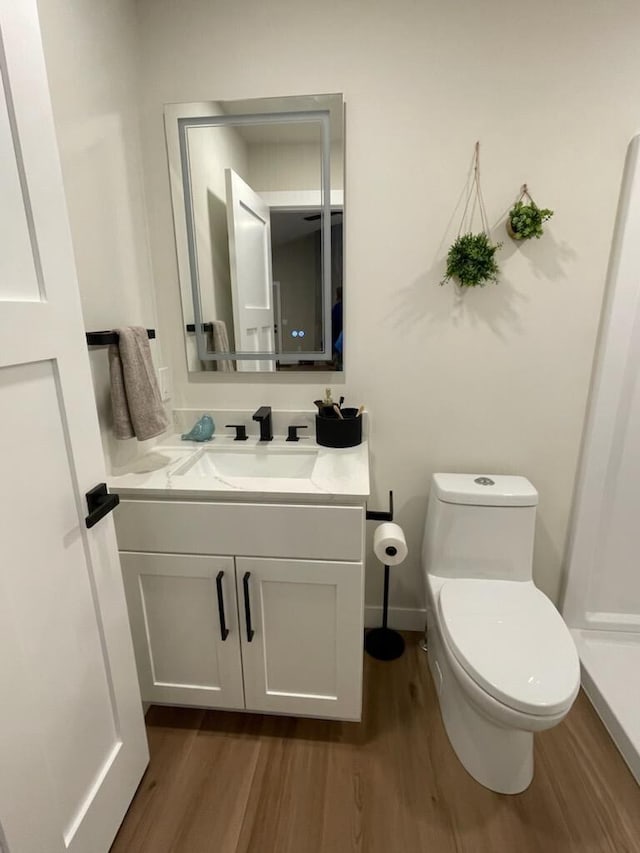 365 13th Dr, Nekoosa, WI 54457 - half bath featuring wood finished floors, vanity, toilet, and baseboards