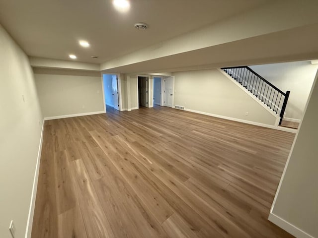 365 13th Dr, Nekoosa, WI 54457 - unfurnished living room featuring stairs, wood finished floors, baseboards, and recessed lighting